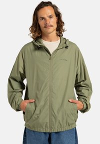 Lichtgewicht, olijfgroene jas met een rits aan de voorkant, verstelbare capuchon en zijzakken. Heeft elastische manchetten en een ontspannen pasvorm.