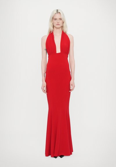 Rotes Neckholder-Kleid, figurbetont, bodenlang, aus weichem Stoff. Mit gefälteltem Detail am Ausschnitt. Schwarze Absätze sichtbar.