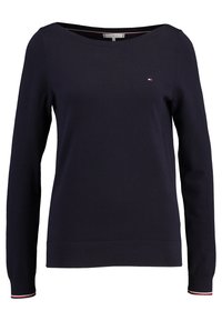 Mörkblå långärmad tröja med rund hals, liten Tommy Hilfiger-logotyp på bröstet och röd-vit-blå kant på ärmarna.