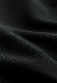 Schwarzer Stoff mit glatter Textur, der feine Rippungen und sanfte Falten zeigt und das Licht sanft reflektiert. Ideal für Bekleidungs- oder Polsteranwendungen.