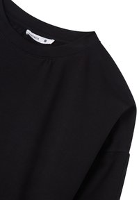Maglietta nera a maniche corte realizzata in morbido cotone, con scollatura tonda e design semplice, con etichetta che indica la taglia "S".
