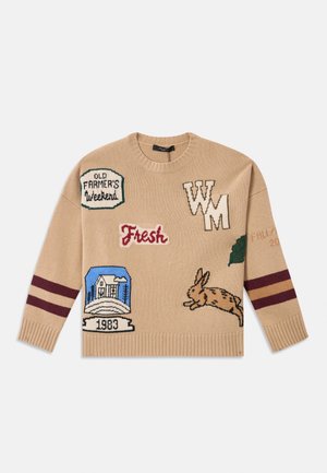 Beige knitted sweater with various colorful embroidered patches, including a rabbit, logos, and stripes in maroon and cream. Round neck design.
