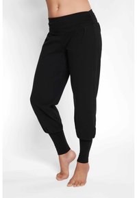 Schwarze, verkürzte Hose mit einem breiten Bund, am Knöchel gerafft, aus einem weichen Stoff und mit einem lockeren Sitz. Glatte Textur ohne Muster.