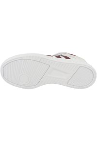 Suela de zapatilla blanca con un patrón texturizado, que presenta un emblema circular y ranuras verticales, acentuada por un diseño de franja marrón.