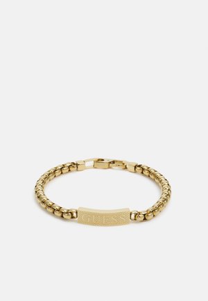 Bracciale in catena d'oro con una barra testurizzata incisa con il nome del marchio. Anelli arrotondati e una chiusura sicura completano il design.