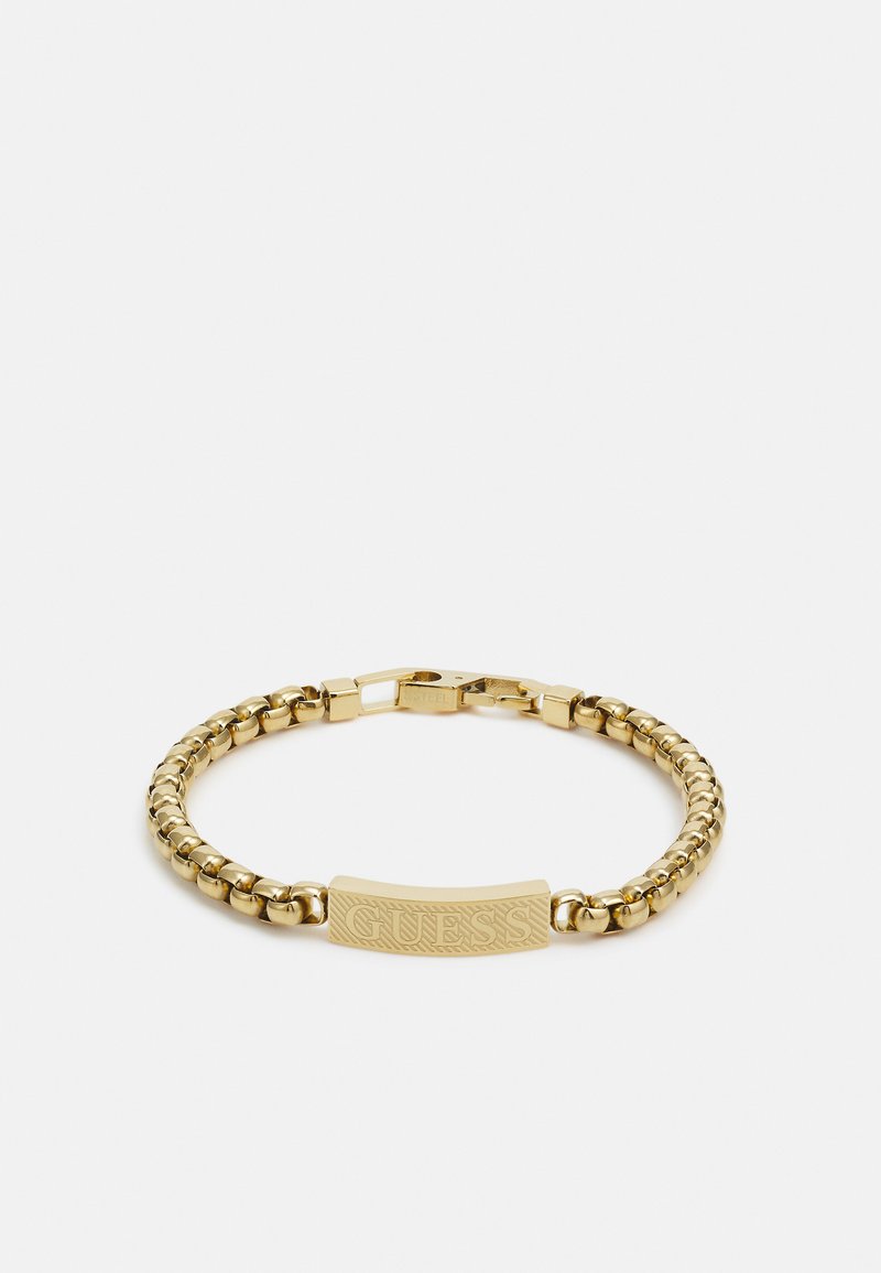 Pulseira de corrente em ouro com uma barra texturizada gravada com o nome da marca. Elos arredondados e um fecho seguro completam o design.