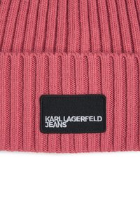 Trikotēta rozā cepure ar vertikālu ribu rakstu. Tam ir melns laukums ar baltu uzrakstu "KARL LAGERFELD JEANS." Mīksta tekstūra.