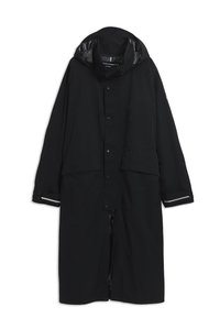 Long imperméable noir avec capuche, boutons-pression sur le devant, deux grandes poches avant et bandes réfléchissantes aux poignets des manches.