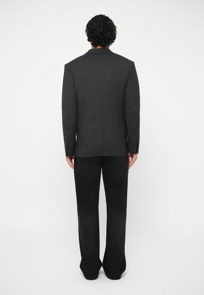 Dark gray plaid blazer with structured shoulders, paired with black flared jeans. The blazer features a single vent and tailored fit.