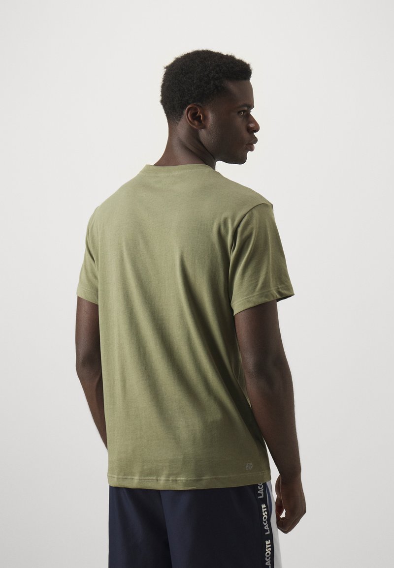 Olijfgroene t-shirt van zacht katoen jersey, met een ronde hals, korte mouwen, en een label aan de zoom met verzorgingsinstructies.