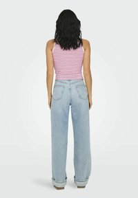 Débardeur rayé rose et blanc ; jean en denim bleu clair à coupe ample avec des ourlets retroussés ; poches arrière visibles et détails de couture.