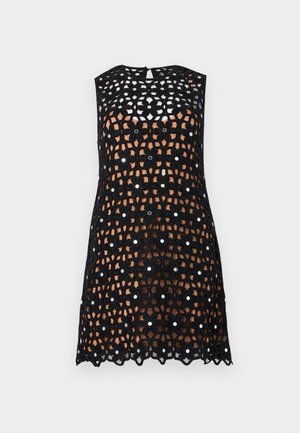 Czarna sukienka bez rękawów, na szydełku, z kwiatowymi wzorami i małymi okrągłymi, refleksyjnymi akcentami, nałożona na cielistą podszewkę.