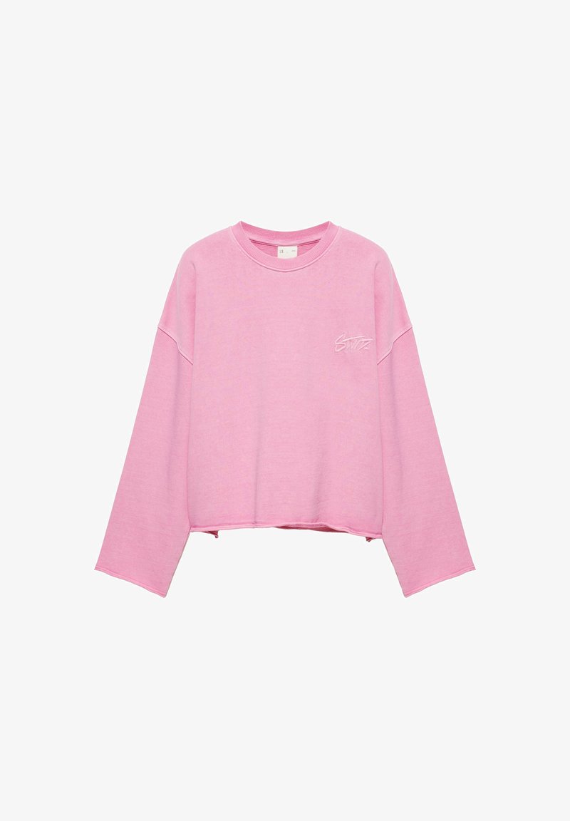 Sweat-shirt court rose à manches longues avec col rond et petit texte blanc brodé sur le côté gauche de la poitrine.