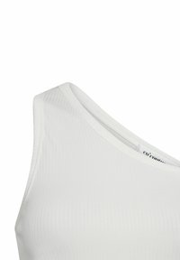 Bílý žebrovaný top bez rukávů s výstřihem do véčka a širokými ramínky, s hladkou strukturou a minimalistickým designem.