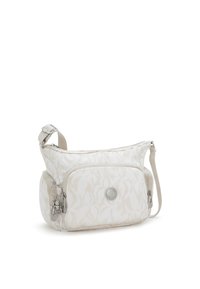 Borsa a spalla beige con motivo, dotata di più scomparti con zip e un piccolo portachiavi a forma di scimmietta attaccato alla cerniera della tasca anteriore.