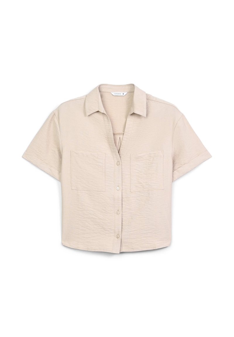 Camicia a maniche corte, con bottoni, di colore beige chiaro e tessuto testurizzato, con due tasche sul petto e colletto. Design piatto, senza decorazioni.