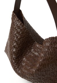 Bolso de mano de cuero trenzado marrón con una forma caída, que cuenta con una suave correa de hombro y un detalle de superficie texturizada.