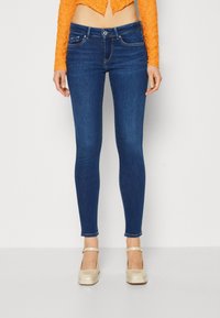 Vaqueros ajustados de denim azul oscuro, con un diseño clásico de cinco bolsillos, cierre frontal de botón y detalles de costura sutiles.