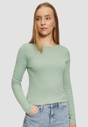 Lichtgroene lange mouwen ribgebreide trui met een ronde halslijn, met opvallende patronen en een aansluitend ontwerp. Gecombineerd met high-waisted denim jeans.