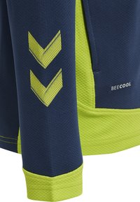 Mörkblå sporttröja i texturerat material med klara gröna detaljer och två zigzag-ränder på ärmen. Varumärkeslogotypen "BEECOOL" synlig.