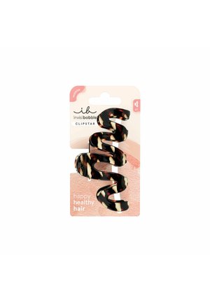 Haarclip met schildpadpatroon en een golvend, spiraalvormig ontwerp, bevestigd op een roze kartonnen achtergrond met het label "happy healthy hair".