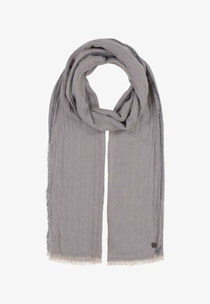 Weicher hellgrauer rechteckiger Schal, gefaltet mit fransigen Kanten und einem kleinen runden Metalllogo in einer Ecke.