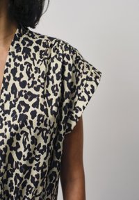 Korte mouwen, beige en zwarte luipaardprint blouse met een relaxte pasvorm en een gladde textuur. De stof heeft een subtiele glans.