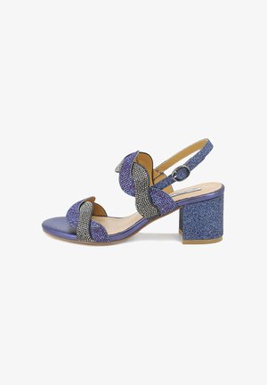 Sandali con tacco glitter viola, con cinturino alla caviglia a fibbia, design scallop e accenti neri. Superficie testurizzata e tacco a blocco.