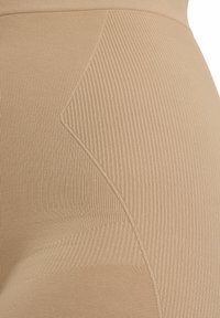 Beige Rippstoff mit strukturierten Paneelen, versehen mit einem glatten Bund und diagonaler Naht entlang der Stoffoberfläche.