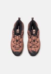 Sport shoes with a mesh upper in a light pink hue, black accents, and flexible lacing system; reinforced toe cap and padded collar.