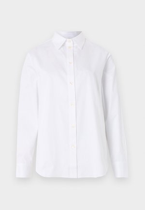 Chemise blanche à manches longues avec col, sept boutons visibles, et un ourlet droit sur un fond clair uni.