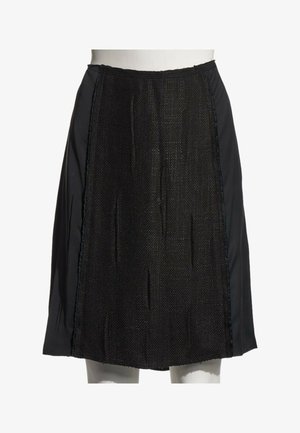 Jupe noire longueur genou avec panneau avant texturé et panneaux latéraux lisses présentée sur un mannequin blanc.