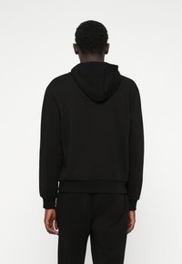 Black sweatshirt with a hood, featuring a ribbed hem and cuffs. Made of a soft, textured fabric. Back view with no visible logos or accents.