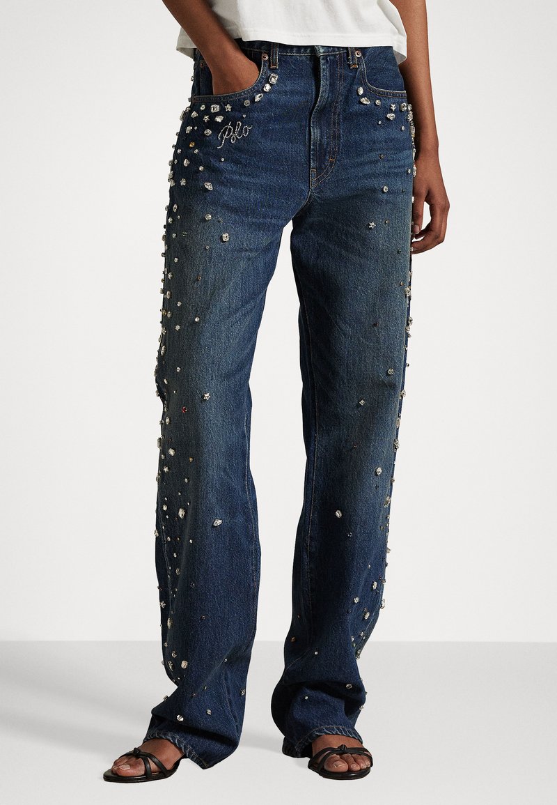 Džínsy s voľným strihom, s rozmiestnenými kamienkami a vyšívanými detailmi na predných vreckách. Tmavomodrá farba.