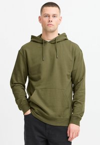 Olive green hoodie in a soft material, featuring a kangaroo pocket, drawstring hood, ribbed cuffs, and relaxed fit.