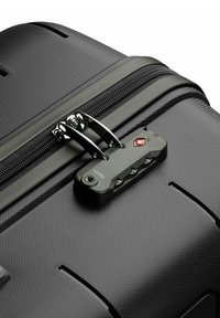 Bagaglio nero con superficie texturizzata, dotato di doppi cursori per cerniera e una combinazione di lucchetto approvata dalla TSA per garantire la sicurezza.