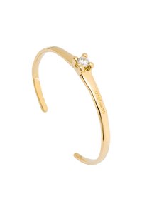 Pulsera de oro con un diseño liso y curvado, y una piedra central clara rodeada por cuatro garras. Presenta un branding grabado.