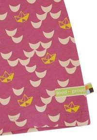 Grafische stof met een roze achtergrond, beige halve cirkel patronen en gele papieren boot ontwerpen. Inclusief een groene label.