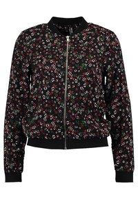 Veste bomber noire à fermeture éclair, avec un petit motif floral rouge, blanc et vert, et des poignets et ourlet côtelés.