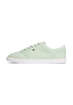 Lichtgroene lage canvas sneaker met witte rubberen zool en een klein rood-wit-blauw vlaglogo aan de zijkant.