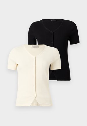 Deux cardigans à manches courtes côtelés à boutons, l'un noir et l'autre blanc, avec des cols en V et une coupe ajustée.