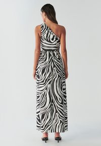 Maxikjole med enkelt skulder i sort og hvid zebra print, med en tætsiddende overdel, flydende nederdel og glat tekstur.