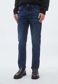 Σκούρο μπλε τζιν με �ίσια γραμμή στο παντελόνι, με διακριτική ξεθώριαση, κλασικό σχέδιο με πέντε τσέπες και ασημί τόνο στα μεταλλικά στοιχεία.