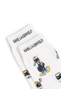 Calzini in cotone con una base bianca e un motivo colorato di un cartone animato che raffigura un'anatra con giacca nera e occhiali da sole. Testo nero "Karl Lagerfeld" in alto.