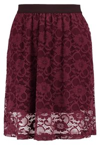 Jupe bourgogne mi-longue avec superposition en dentelle florale et taille noire, présentant un détail de bord en dentelle semi-transparente.
