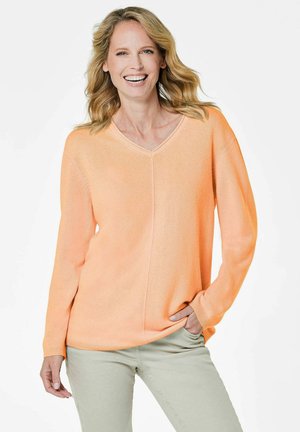 Hellorange gestrickter Pullover mit V-Ausschnitt, langen Ärmeln und lockerer Passform. Die Textur wirkt weich und glatt, mit einem subtilen Glanz.
