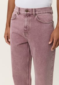 Ροζ τζιν παντελόνια σε ανοιχτή απόχρωση, με κλασικό σχέδιο πέντε τσεπών, κανονική γραμμή, διακριτικές ραφές και κλείσιμο με κουμπί μπροστά.