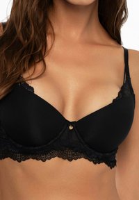 Czarny koronkowy stanik z gładkimi miseczkami, dekoracyjną koronkową lamówką, regulowanymi ramiączkami i złotym akcentem na środku.