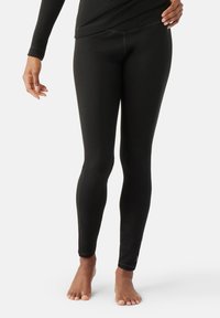 Svarta leggings i mjukt, elastiskt material, med en figurnära design och sömlösa sidor, prydda med en diskret logotyp vid ankeln.