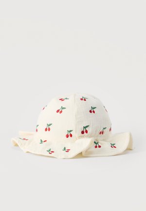 Chapeau de soleil pour bébé crème avec bordure à volants, décoré de petites cerises rouges brodées et de feuilles vertes.